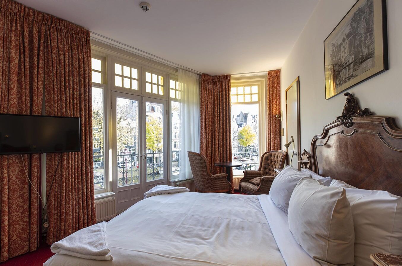 Corner room with french windows onto the canal, two armchairs and a table between them